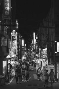 People walking on city street at night