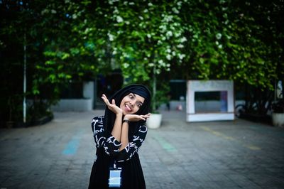 Playful woman gesturing while standing at park