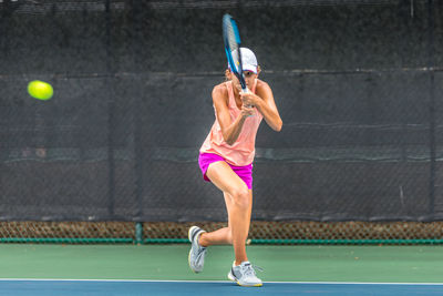 Teenage girl playing tennis on court