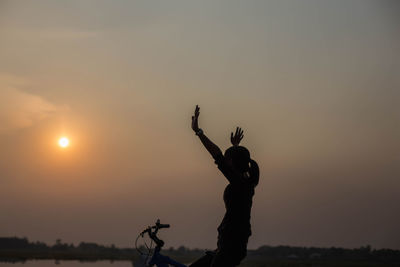 Silhouette people standing against sky during sunset