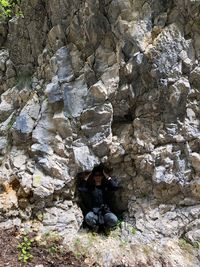 Man crouching under rock