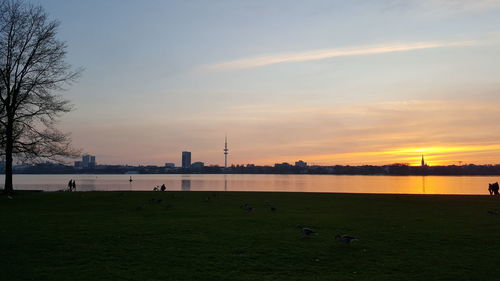 Scenic view of alster river against sky during sunset