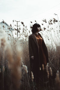 Woman standing on field against sky