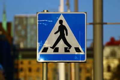 Close-up of road sign against blue sky