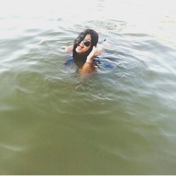 water, waterfront, rippled, swimming, young adult, lifestyles, leisure activity, person, high angle view, lake, portrait, looking at camera, front view, day, nature, outdoors, full length, young women