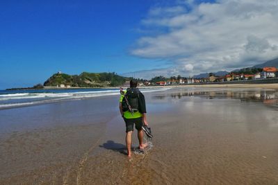 Rear view of woman walking on beach