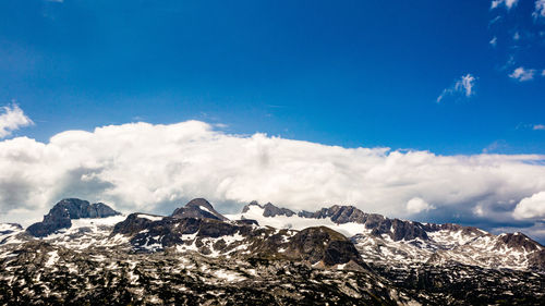 Scenic view of snowcapped mountains against blue sky