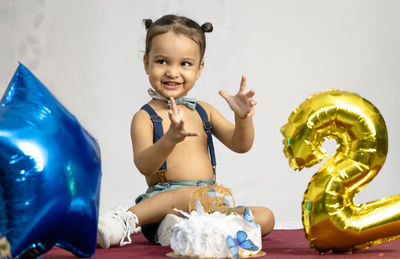 Indian baby boy happy moments at birthday celebration with white background at indoor