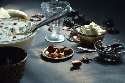 High angle view of ice cream in bowls with peanut butter cupcakes and chocolates on table