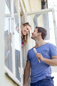 Young couple painting windows, stockholm, sweden