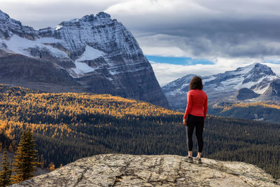 Rear view of woman standing on snowcapped mountain