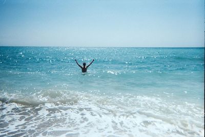 Man swimming in sea against clear sky