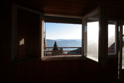 Scenic view of mountains against sky seen through window