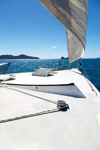 Sailboat sailing in sea against clear blue sky