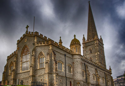 Low angle view of bell tower against cloudy sky