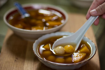 Close-up of hand soup in bowl on table