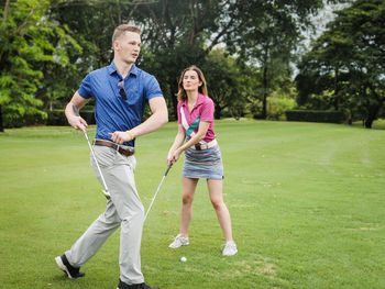 Full length of couple playing golf 