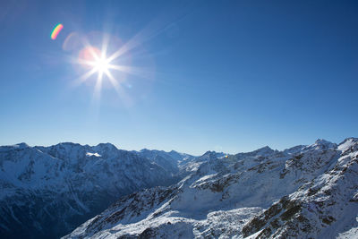 Scenic view of snow mountains against clear blue sky