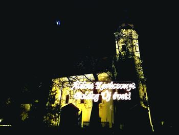 Low angle view of illuminated clock tower against sky