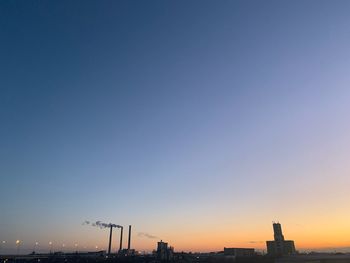 Silhouette of buildings against clear sky during sunset
