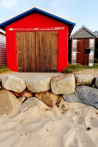 Red structure on sand against sky