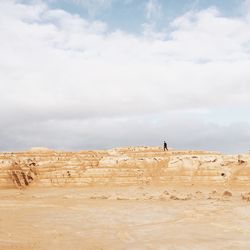 People standing on land against sky