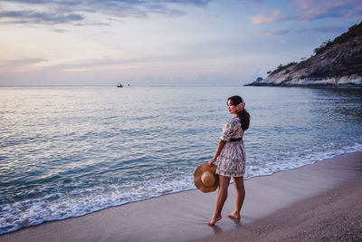 Full length of woman on beach against sky