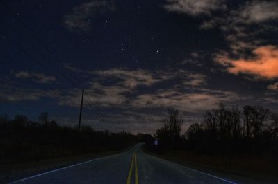 Empty road against cloudy sky