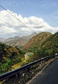 Road by mountain against sky