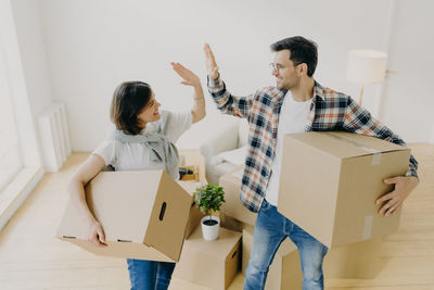 Couple holding boxes on home