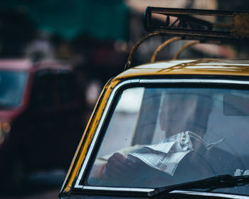 Close-up of yellow car on street