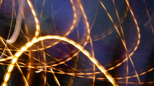 Close-up of light trails against sky at night