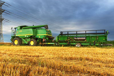 Tractor on agricultural field against sky