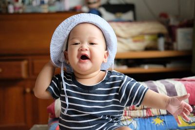 Portrait of cute baby boy in hat at home