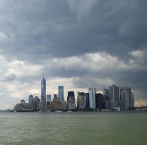 Sea by cityscape against sky