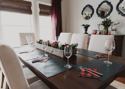 Table set for a formal christmas holiday dinner in a dining room.