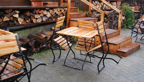 High angle view of empty wooden chairs and table at cafe