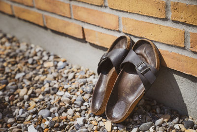 Close-up of shoes on stone wall