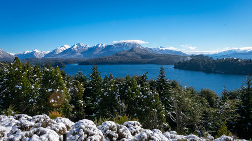 Scenic view of lake and mountains against blue sky