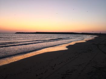 Scenic view of beach against sky during sunset