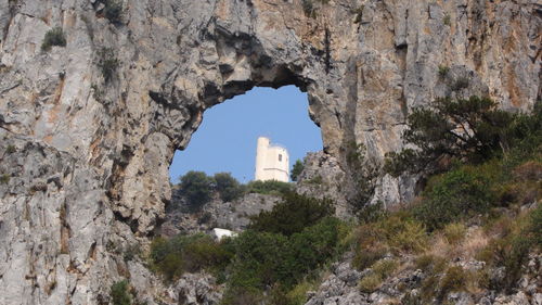 Buildings seen through arch of rock formation