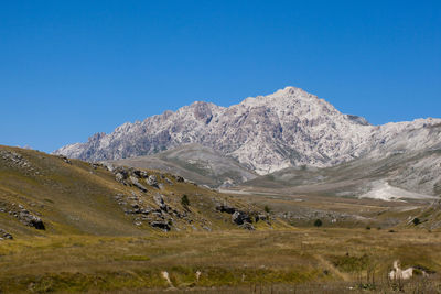 Scenic view of mountains against clear blue sky