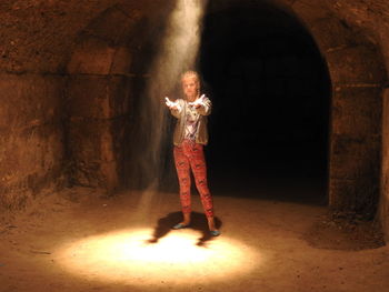 Sunlight falling on girl standing in underground
