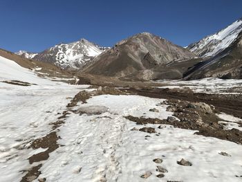 Scenic view of snowcapped mountains against clear blue sky