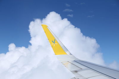 Low angle view of yellow flag against blue sky