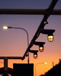 Low angle view of illuminated light against sky at sunset