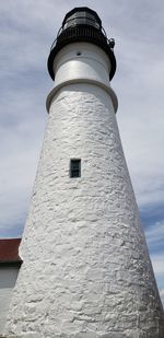 Low angle view of lighthouse against building