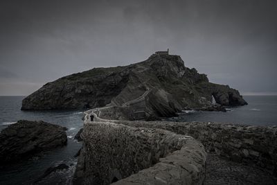 Rock formation on beach against sky