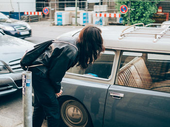 Profile view of woman standing near car