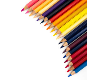 High angle view of multi colored pencils against white background